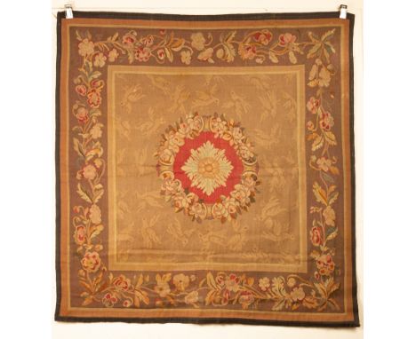 An Aubusson style Tapestry, the soft brown field centred by a circular floral wreath rose medallion, framed by an aubergine b