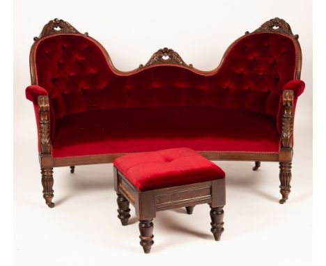 An early Victorian upholstered sofa of gentle crescent shape and carved mahogany frame, the double chair back with buttoned u