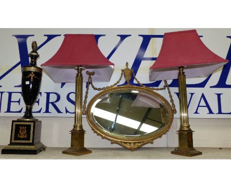 An Adam style oval wall mirror in gilt frame with vase and flags; a pair of modern brass Corinthian column lamps and shade; a