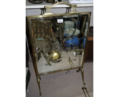 An Art Nouveau brass framed firescreen with decorative mirror panel