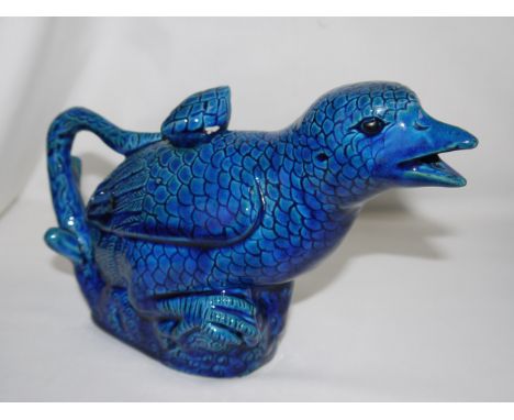 An unusual Chinese teapot in the form of a bird on a branch, under deep blue glaze, length 8½" (chips to stopper, rim and lea