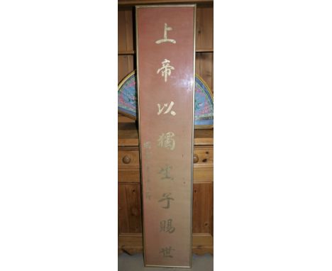 A Chinese scroll with gilt characters on a pink background, framed and glazed, height 61"