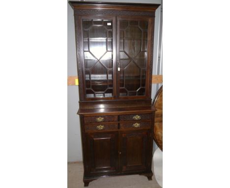 A late 19th century Chippendale style full height cabinet in dark mahogany, with blind fret decoration, 2 astragal glazed doo