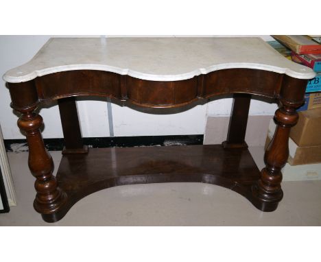 A Victorian mahogany washstand with serpentine front, marble top, double doors and shelf below, on column legs