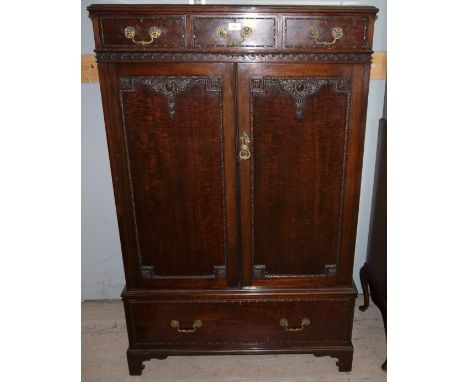 A mahogany reproduction press cupboard with beaded decoration, 3 small frieze drawers, double cupboard fitted with sliding do