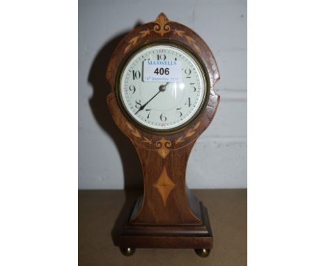An Edwardian inlaid mahogany mantel clock with balloon top and French movement; a miniature silvered item; a brass dog