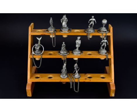 Ten Decorative Novelty Wine Stoppers housed in a pine rack with a capacity to hold 18 stoppers. To include stoppers in the fo