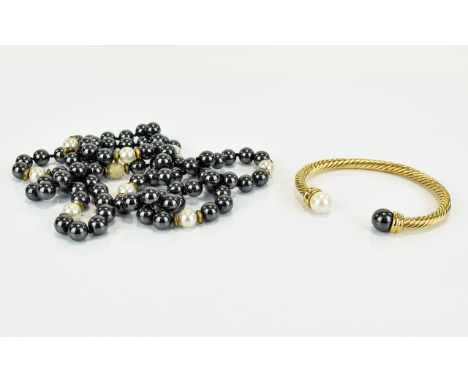 A Long faux Pearl Necklace And Matching Gold Tone Cuff By Cabouchon Long necklace strung with obsidian tone faux pearls, set 