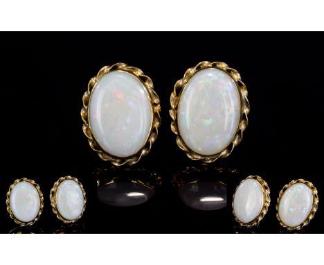 A Nice Pair of 9ct Gold Opal Set Earrings. The Opals are Well Matched - Oval Shaped within Fancy / Ornate Mounts. Fully Hallm