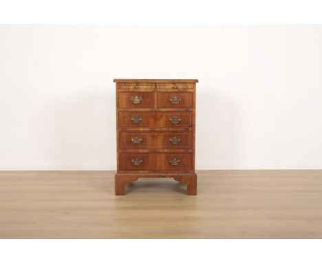 A SMALL FIGURED WALNUT CHEST OF DRAWERSof early 18th century design, with 'book matched' veneered top, fitted slide, two shor