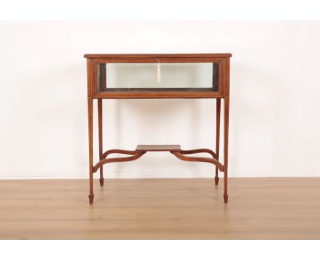 AN EDWARDIAN INLAID MAHOGANY BIJOUTERIE TABLEwith inlaid satinwood stringing, moire silk lined display area, the curved stret