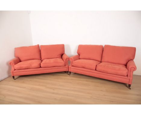 A PAIR OF SOFAS BY GEORGE SMITHupholstered in terracotta linen, with castored block wood feet, 187cm long x 105cm deep x 79cm