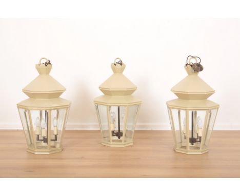 A SET OF THREE PISTACHIO PAINTED METAL HALL LANTERNSthe octagonal tapered bodies with bevelled glass and four electric sconce