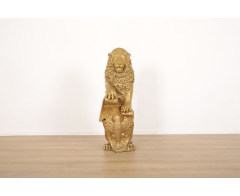 A GILT PLASTER STANDING LIONthe front paws resting on eagle decorated bracket, 103cm high x 32cm wide x 55cm deep