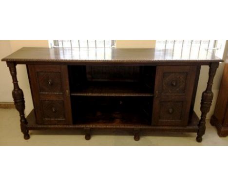 A vintage oak sideboard with carved pedestals and lion head decoration to doors and panels. 7' / 213cm long.
