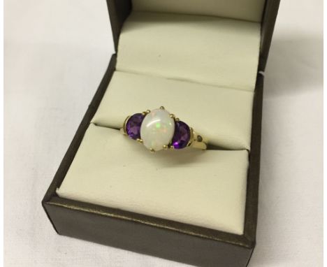 Pretty 9ct gold ladies dress ring set with a central oval opal stone with amethysts either side. Size S½.