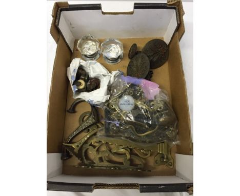 A box of vintage brass furniture door handles, hooks, ceramic casters and other items.