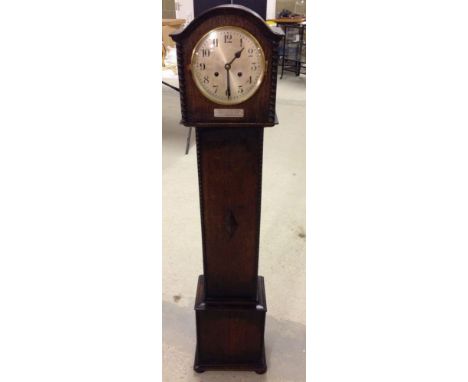 A 1930's Grandaughter clock with lozenge motif to front of case and moulding edges. In full working order, bears a small plaq