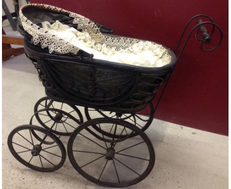 Vintage ornate dolls pram, ideal for doll display. Edged with lace.