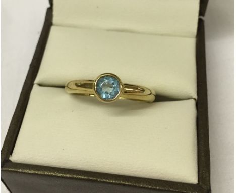 9ct gold ladies dress ring set with a blue topaz. Size R.