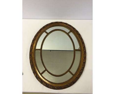 Vintage gilt framed oval mirror with beaded edge panels and leaf decoration to outside border. Size approx 68cm x 54cm.