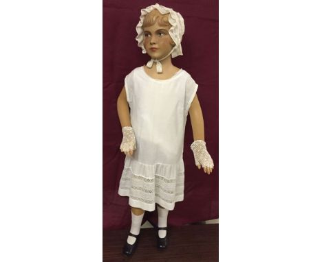 A c1950s vintage girl shop mannequin with painted face. Approx 120cm tall with moulded hair and dressed.