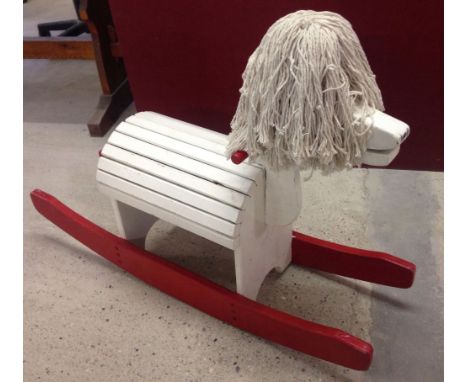 Vintage wooden rocking horse with mop head.