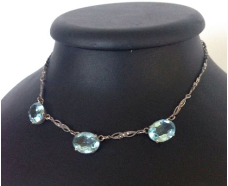 A silver and marcasite necklace set with 3 large oval blue topaz stones.