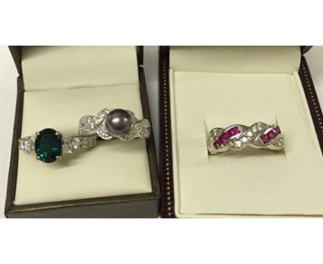 3 pretty silver rings, one with red & white stones, one with green & white stones and the other with a faux pearl.