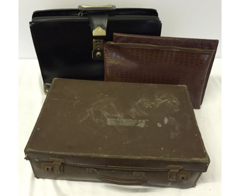A vintage black briefcase with key, containing 2 faux crocodile skin document holders and a small vintage brown suitcase.