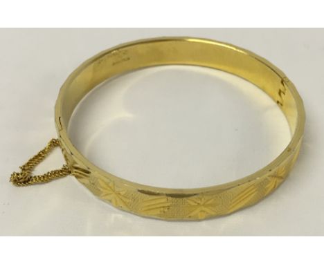 18ct rolled gold bangle with engraved decoration and safety chain.