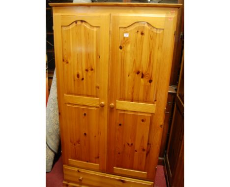 A modern pine double door wardrobe, having single long lower drawer