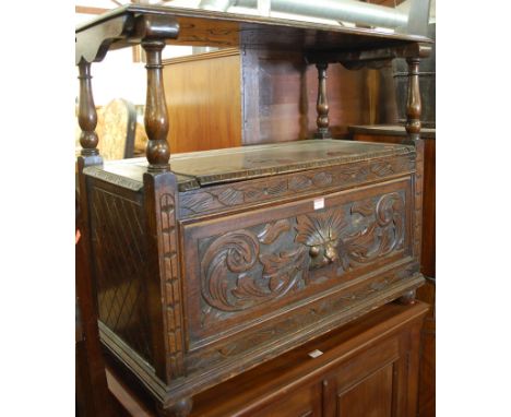 An early 20th century low relief carved oak fold-over monks bench having a typical hinged box seat base, width 92cm