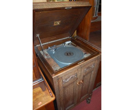 An early 20th century moulded oak hinge-top freestanding gramophone by His Master's Voice The Gramophone Company Ltd, Hayes, 