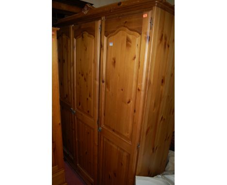 A modern pine three door wardrobe