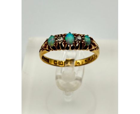 18ct gold ladies ring, three blue tone opal stones, mounted with two diamonds Weight - 3.17g Size - N