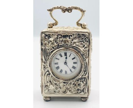 Small silver cased carriage clock William Comyns, London 1900, the case with all over chased floral decoration and white enam