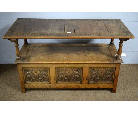 An early 20th Century carved oak monk's bench, 124 x 53 x 78cms with top raised.