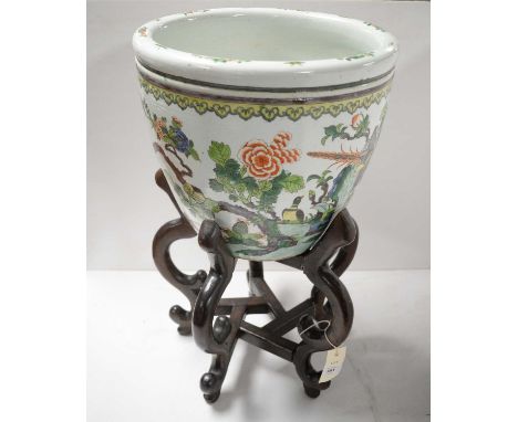 A Chinese ceramic planter, decorated with tropical birds within foliate landscape scene, raised on a stained carved hardwood 