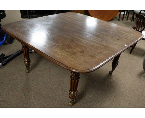 A substantial Victorian mahogany extending dining table, the rounded rectangular top opening to fit three additional leaves, 