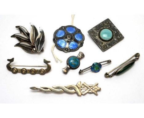 A silver and blue enamel button; a Ruskin style ceramic cabochon and pewter brooch; a silver and blue stone brooch; a Danish 