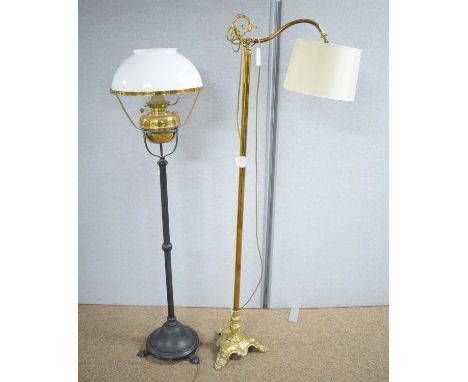 An ornate brass reading lamp (converted from a 19th Century oil lamp), with modern shade, 166cms high; and a black painted ca
