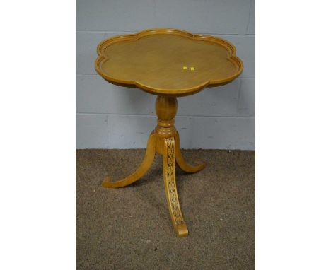 A modern decorative tripod table with shaped circular top and leaf-carved down-swept legs, 61 x 72cms high.