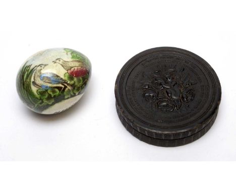 An early 19th century pressed horn circular snuff box by W.Wilson Jr, the cover decorated in relief with a cherub amongst flo