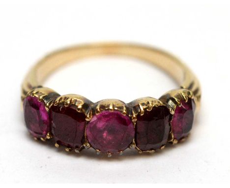 A 19th Century ruby ring, set with four rubies and one replacement paste stone, on gold shank (tests at approximately 14ct), 