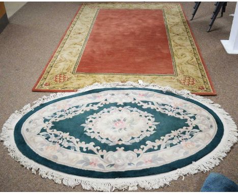 A machine-made rug in a classical style with pink field within acanthus scroll border, 254 x 160cms; together with an oval Ch