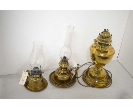 Two brass chamber oil lamps, each with clear glass funnel; together with a Duplex brass oil/table lamp, later wired for elect