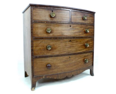 A Regency mahogany bow fronted chest of two short over three long graduating drawers, with cock beading and brass circular ha