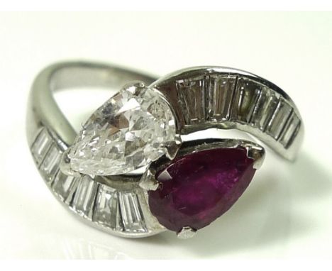 A platinum crossover ring set with a pear cut diamond, approx 0.5ct, and pear cut ruby, of similar size, flanked by twelve fu