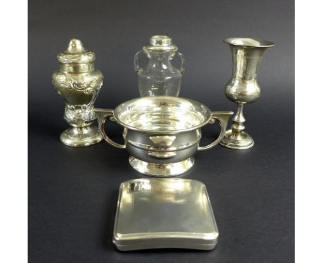 An unusual Victorian silver pepper pot, the curved body chased and embossed with scrolls and foliage, vacant cartouche to one